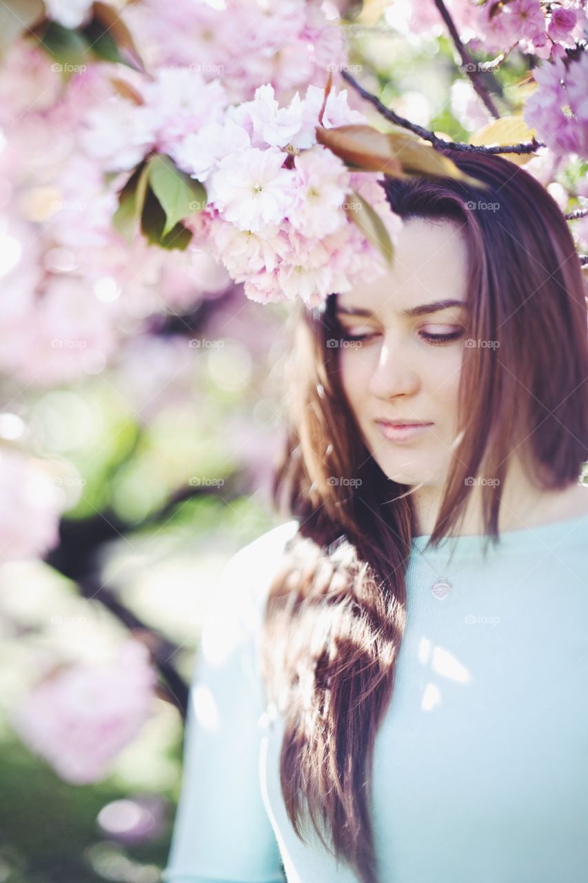 Woman standing under cherry tree