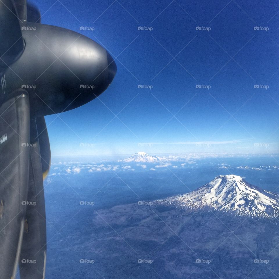 View of snow capped mountains and the propeller of a plane. 