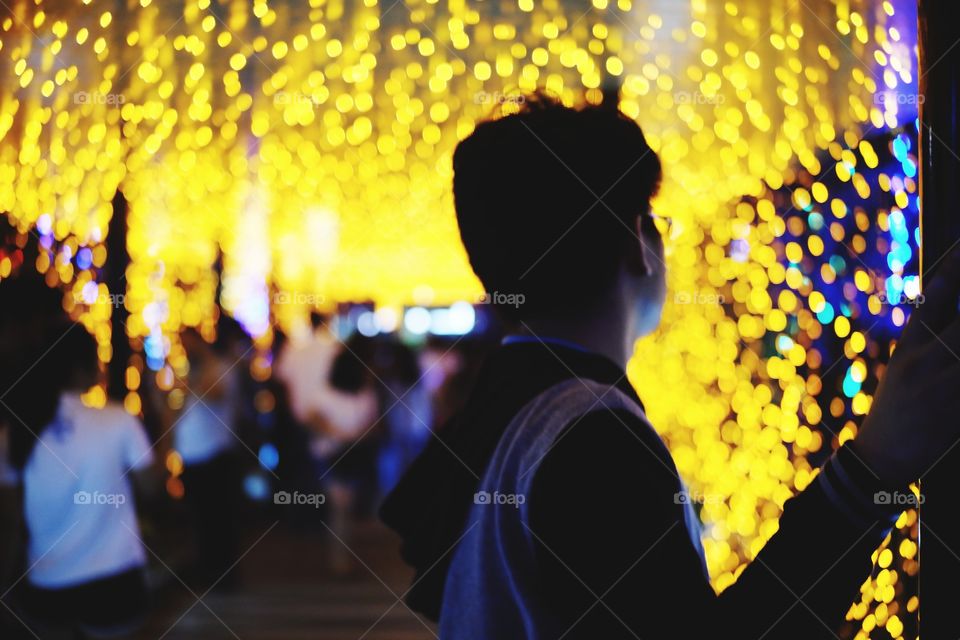 Man standing behind yellow lights