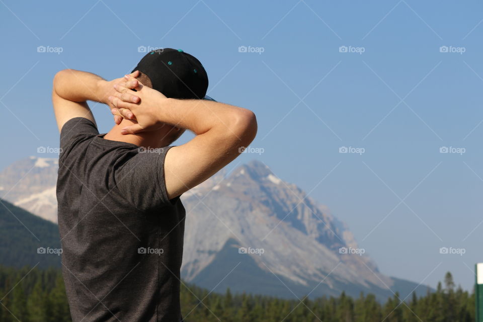 Young man viewing snow-capped Canadian Rocky Mountains 