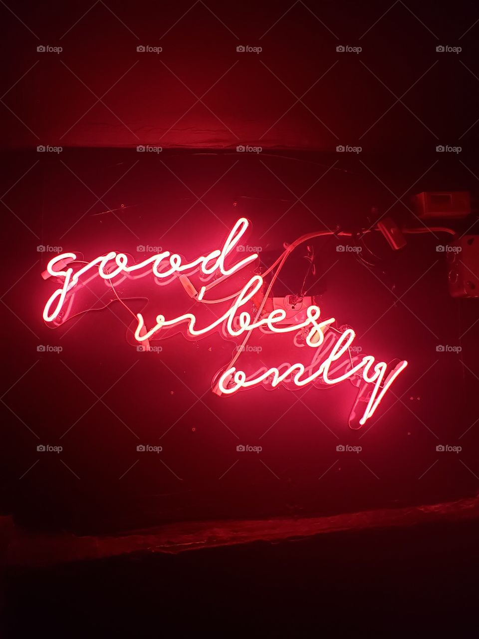Good vibes only; luminous pink neon sign from basement in bar, downtown Toronto, Canada.