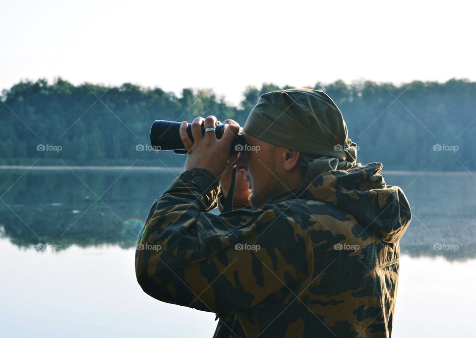 A man looks through binoculars