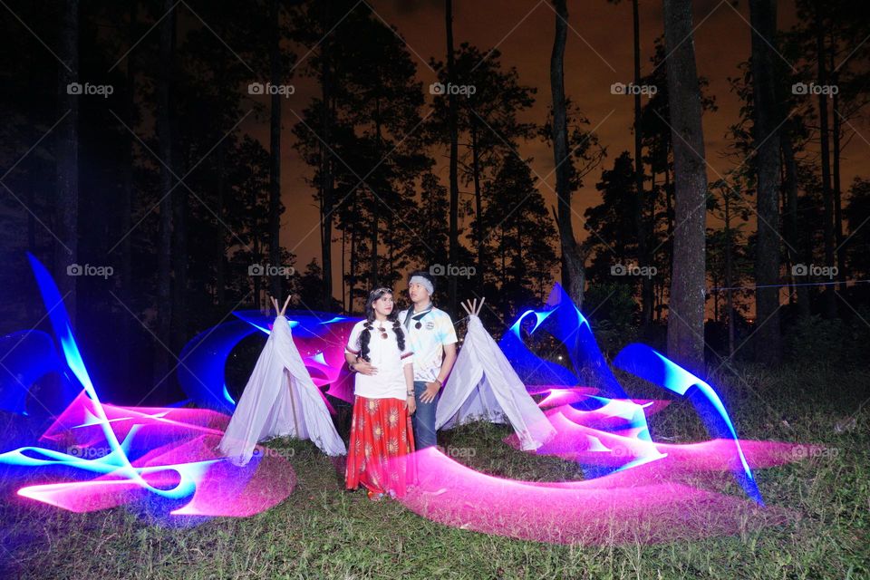 valentines miracle, my wife and I are posing for a wedding photo.  with a hippie theme and photographed using lightpainting techniques