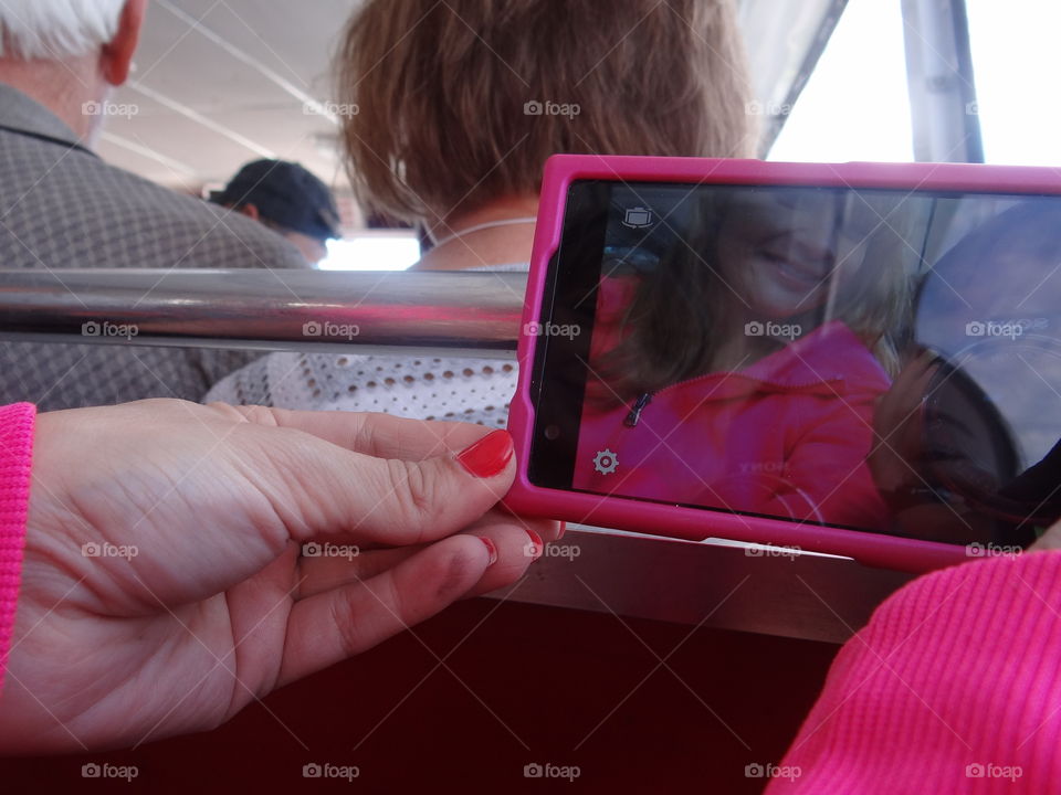 Picture in picture . Mother and daughter taking a selfie as little girl holds up large camera to take picture 