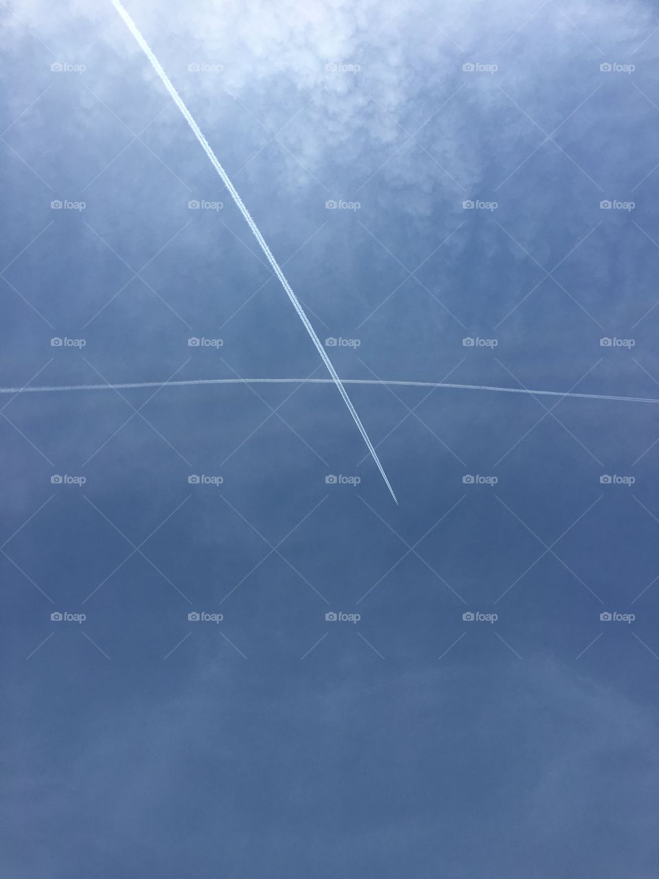X in the sky; Jet stream of two aircraft crisscrossing each other in the sky 
