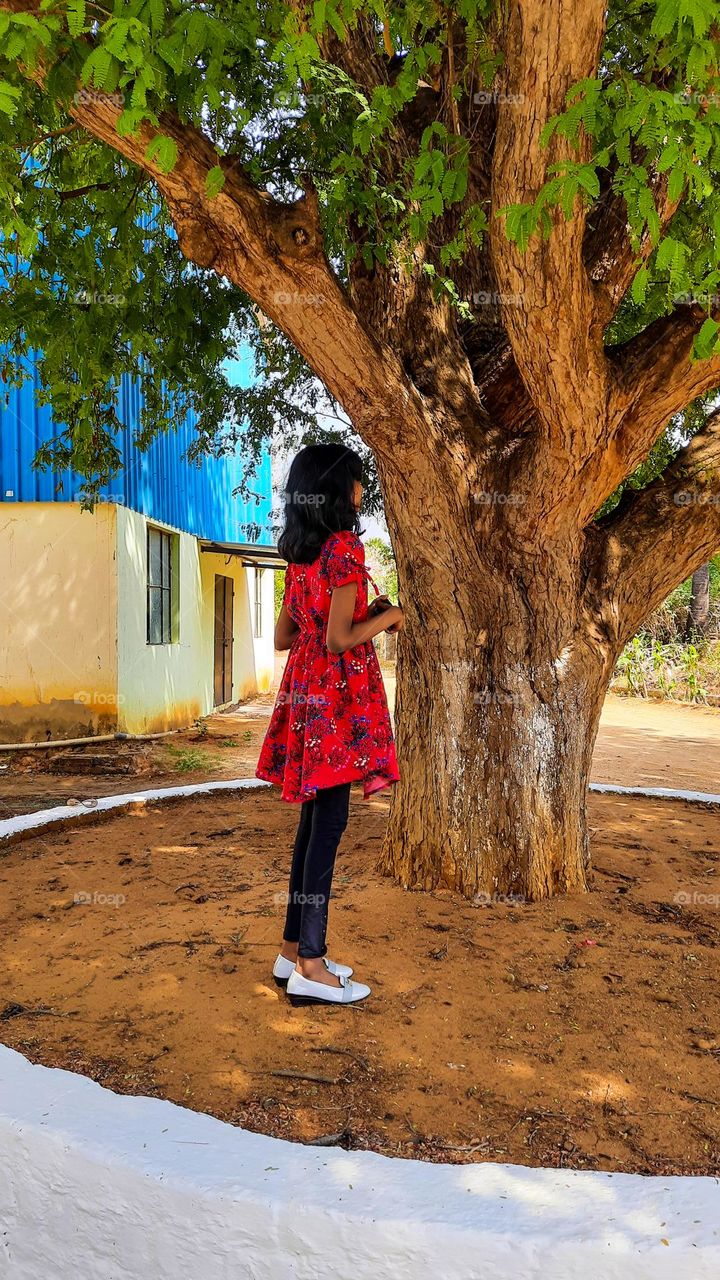 A girl standing near the tamarind tree