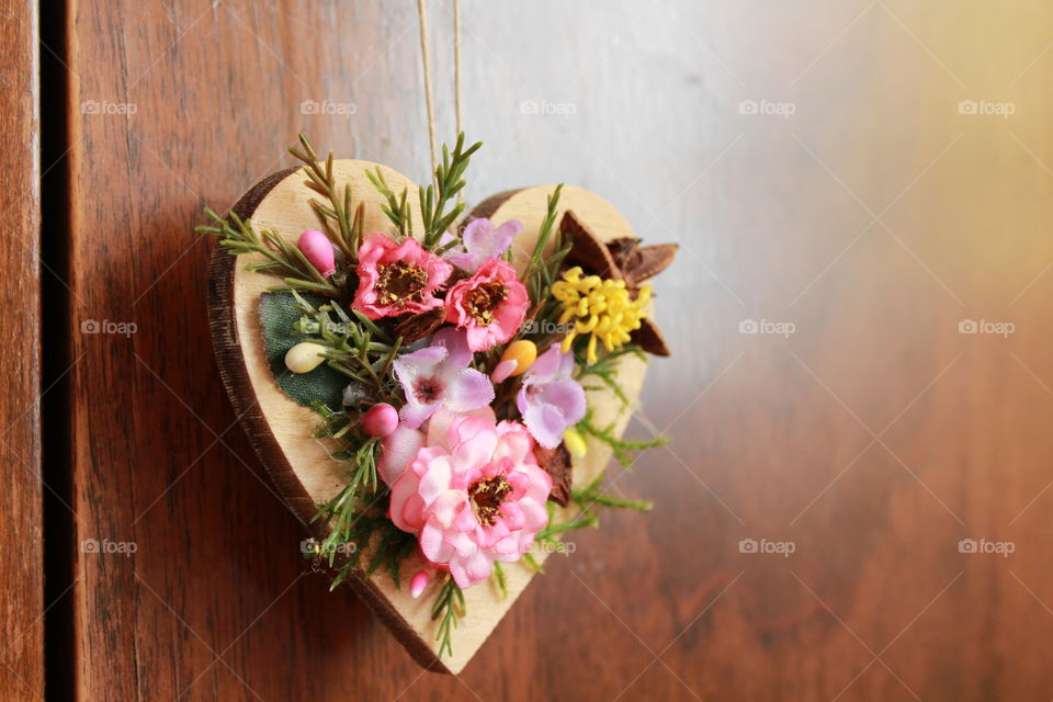 beautiful wooden hear with flower decorations against the closet door