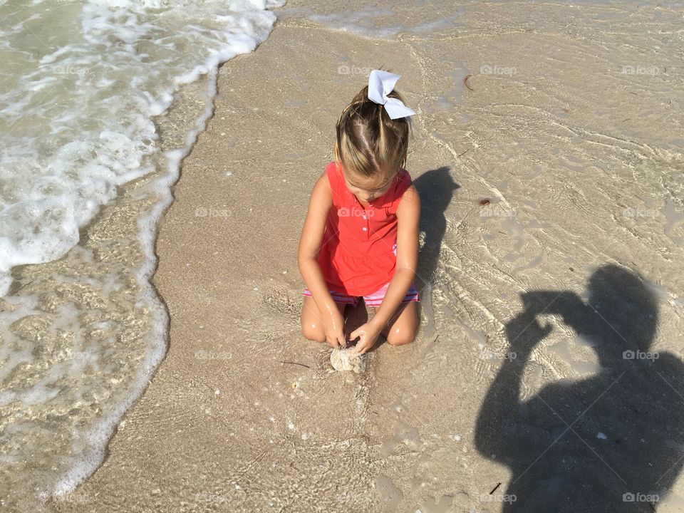 Little girl playing on the sand on a yucatan Peninsula beach 
