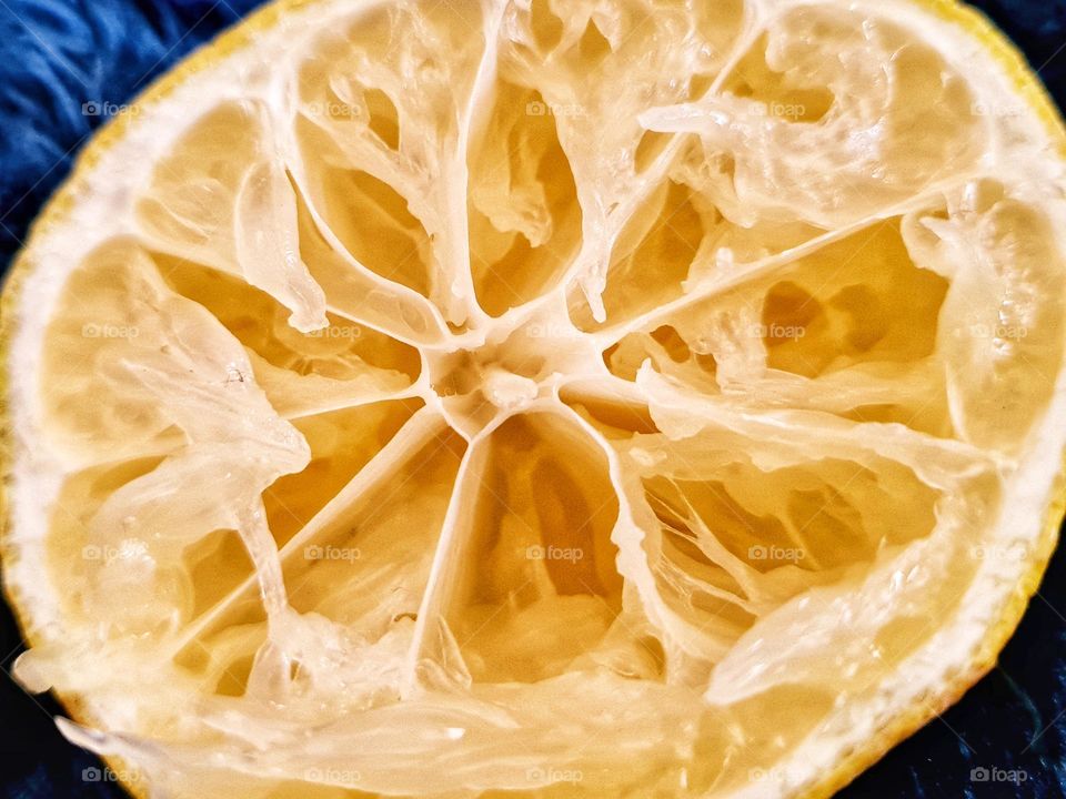 close up photo of a lemon sliced in half. All the juice has been squeezed out by hand