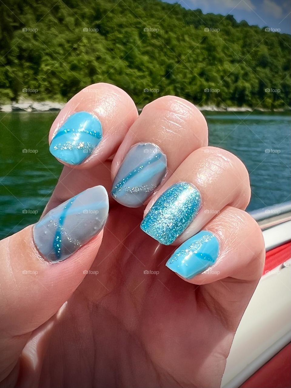 Looking my multi shade blue gel nails on a hot summer day on the lake 