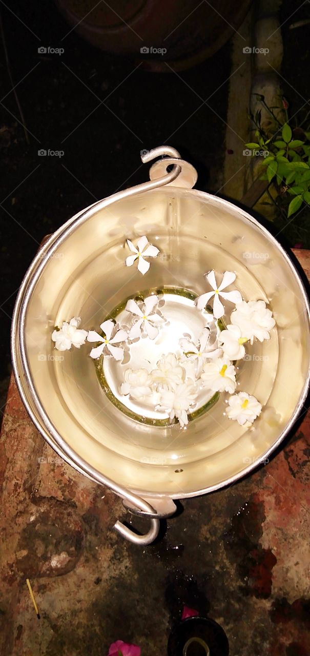 steel bucket filled with water filled with white flowers