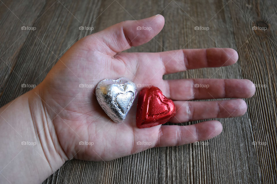 Hand holding heart shaped candy
