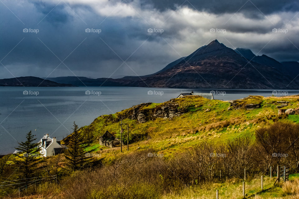 Dramatic storm clouds move in from the sea towards the Cuillin mountains on the Isle of Skye, Scotland