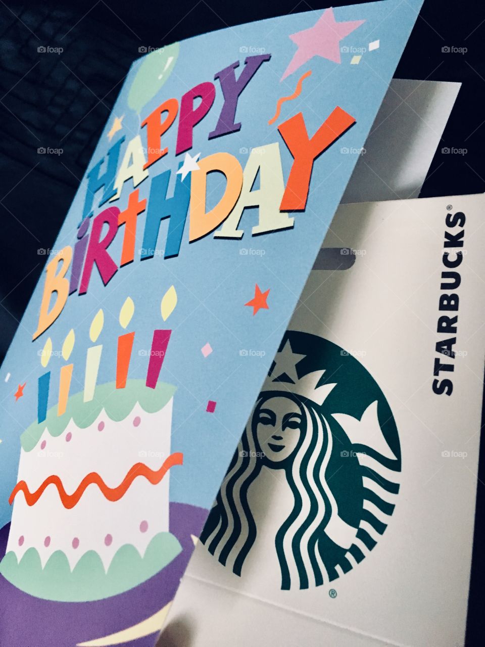 The best birthday gift to get or give: a Starbucks gift card! Blue Greeting card that says Happy Birthday with a Starbucks gift card inside. 