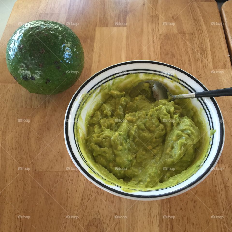 Large avocado and bowl of egg salad made with avocado as a substitute for mayo. 