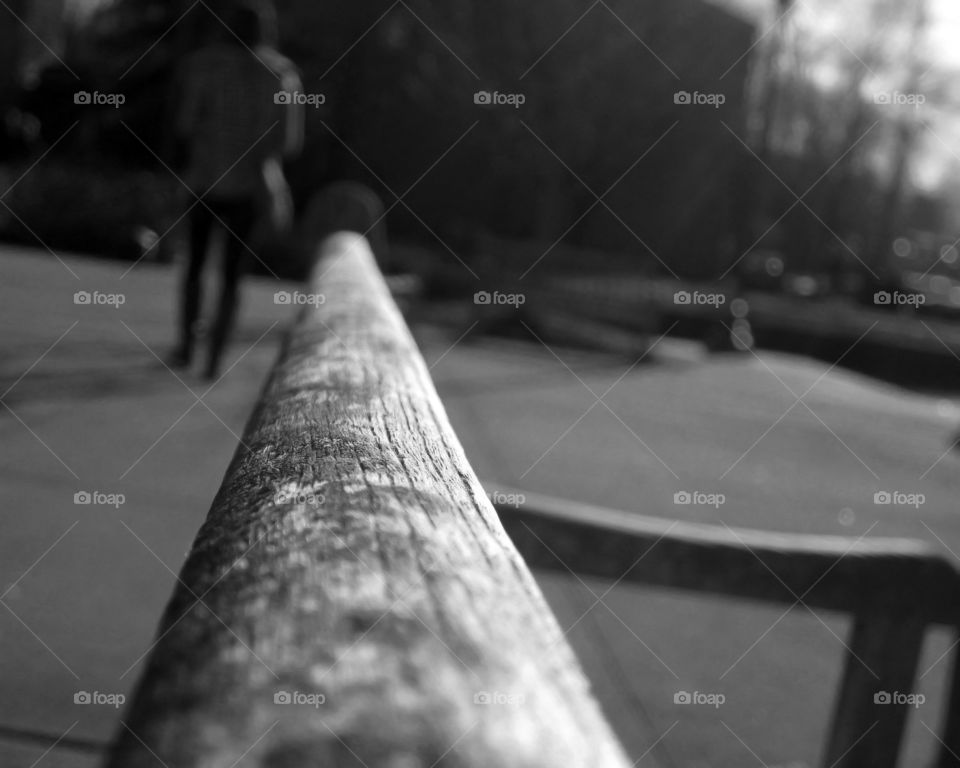 Close up of bench & girl walking away. 