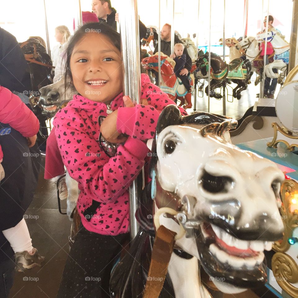 Girl smiling on carousel 