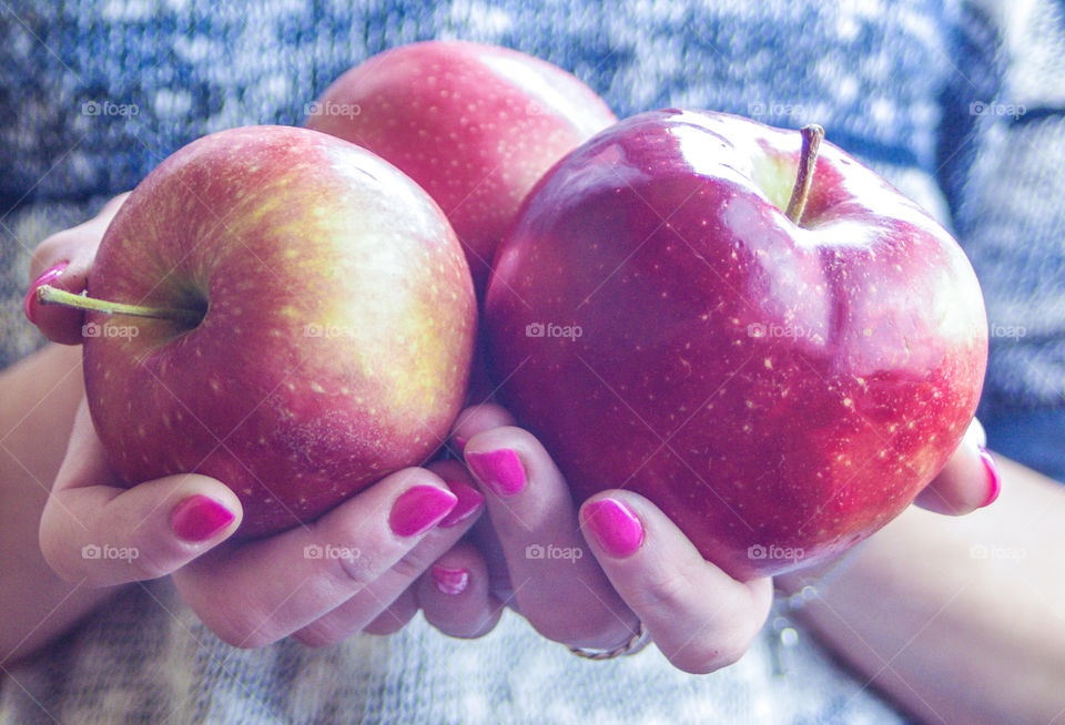 The girl is holding an apple