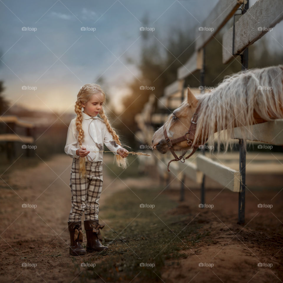 Portrait of little girl with  horse