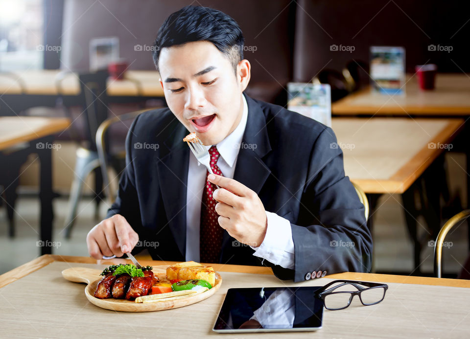 Asian businessman eating cooked food