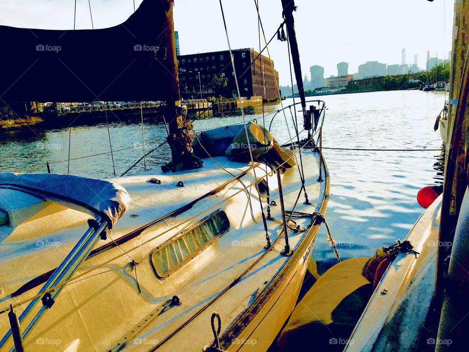Boats in Newtown Creek, Long Island City, Queens, New York in the early evening. As the sun is setting it bathes everything in a warm golden light. Photo 2018. Hypnotic Productions