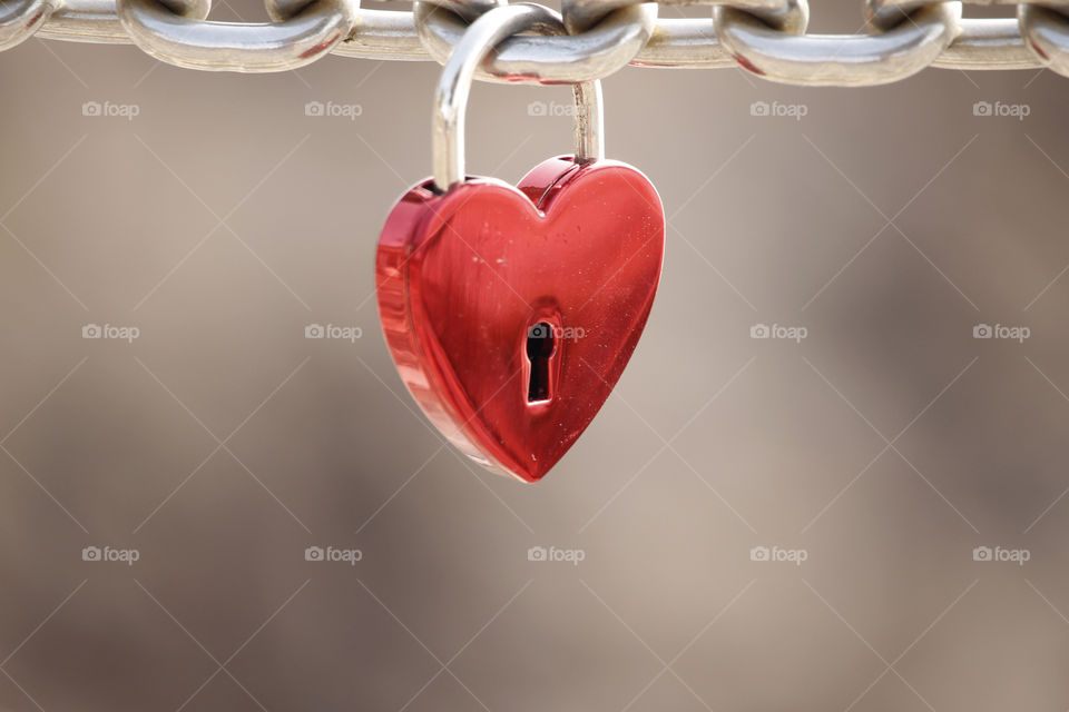 Love, red heart shaped padlock hanging on a metal chain - kärlek, rött hänglås format som ett hjärta hänger på en kedja av metall 