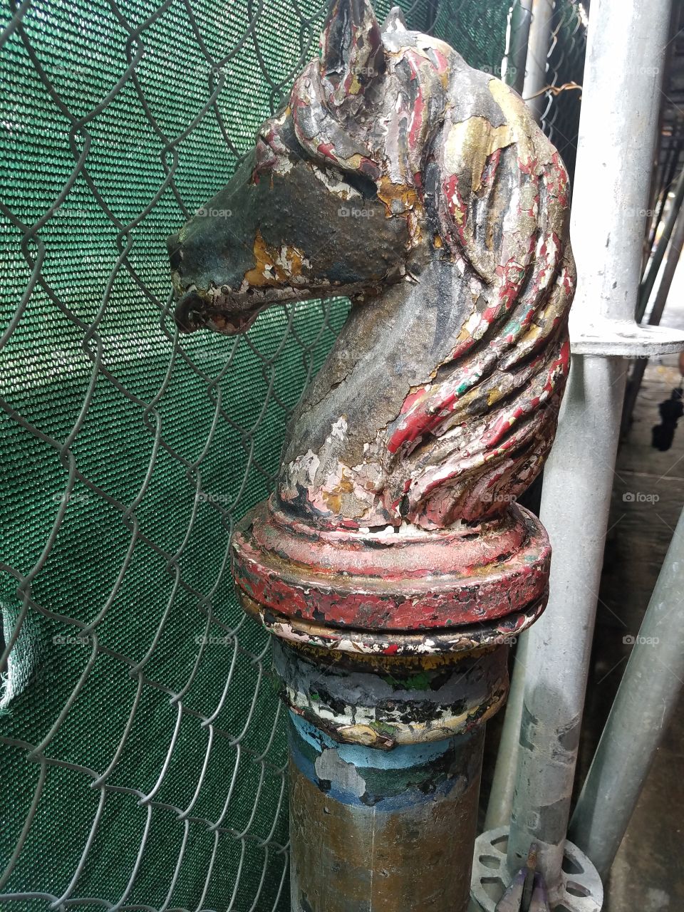 Old New Orleans police horse hitching post with many years of paint layers amid street construction.