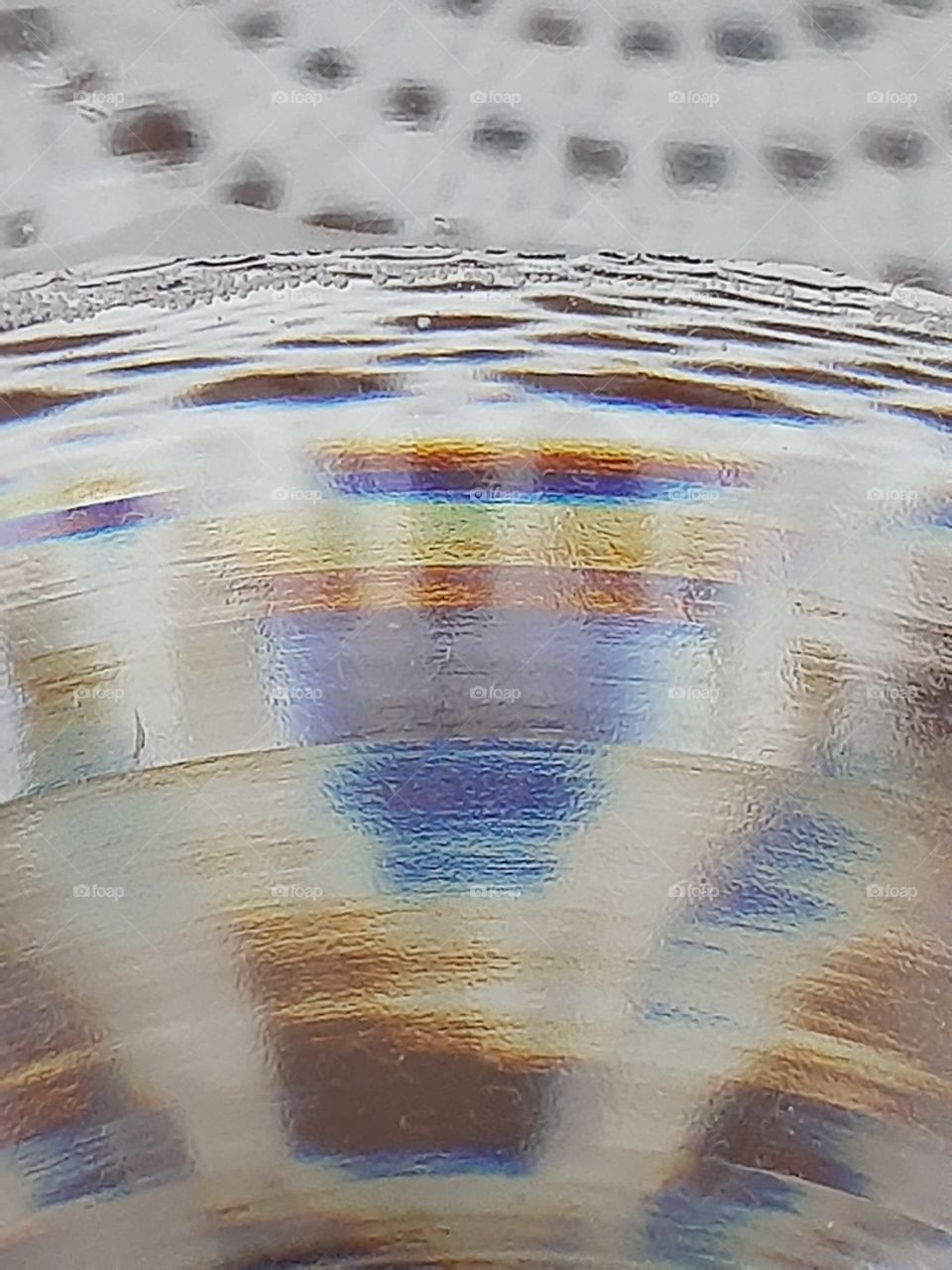 a vabriations  of colors from a one glass of water on the table with white cover.