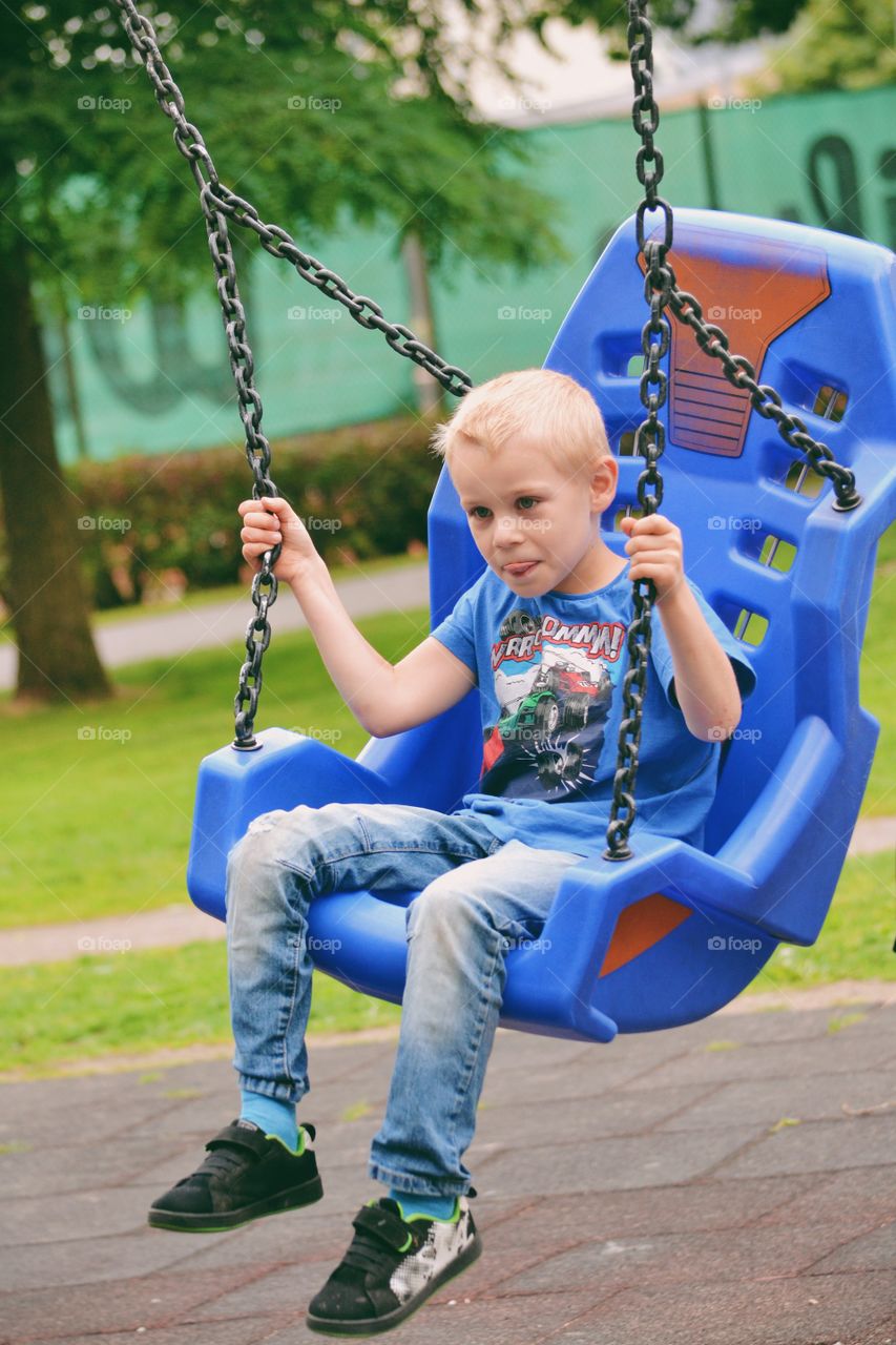 Boy swinging at the playground