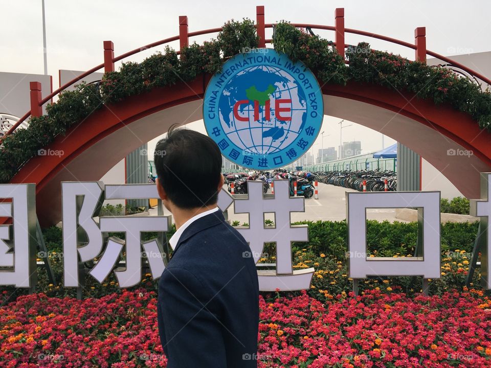 A Chinese man near a China International Import Expo sign in Shanghai