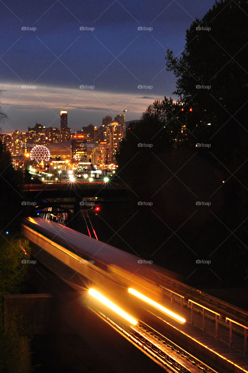 Nighttime view of downtown Vancouver British Columbia with Translink A in foreground.