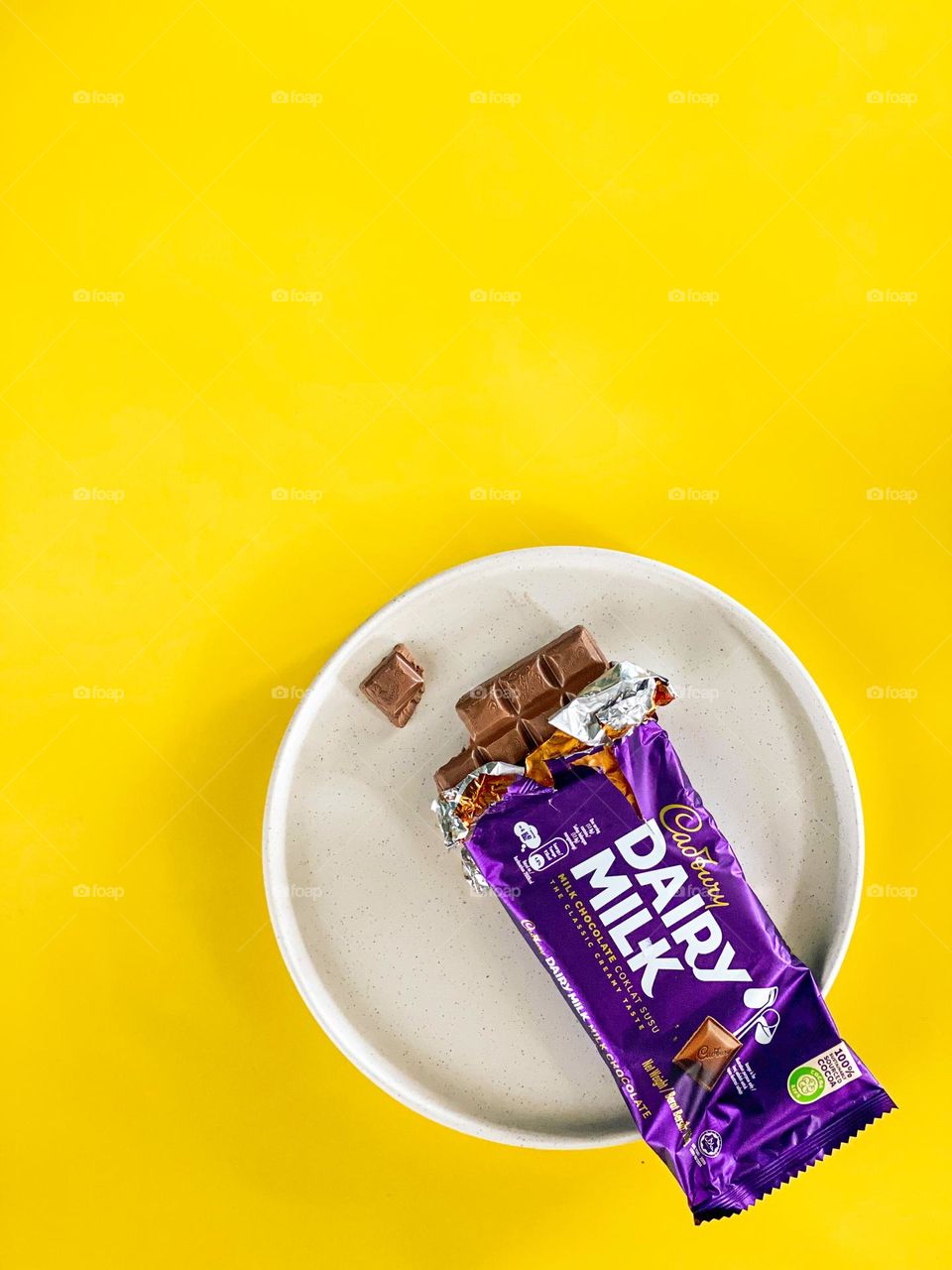 Chocolate wrapped in purple on a yellow background.