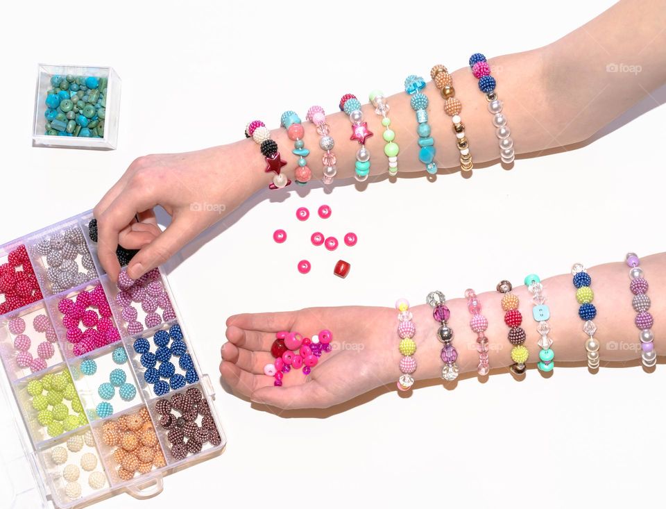 Kid making bracelets out of colorful beads 