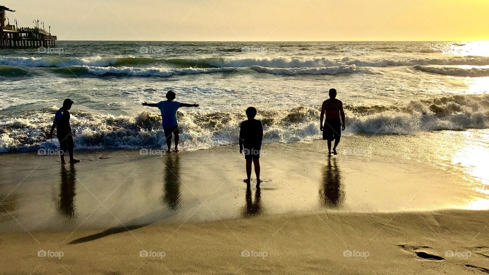 Kids at play on a sunset lit beach.