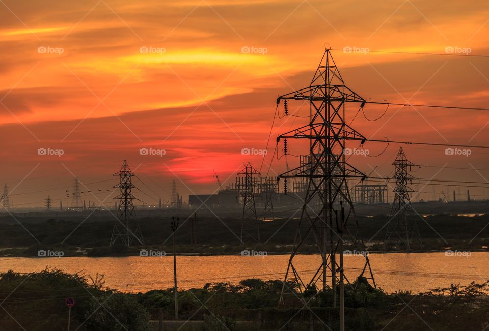 sunset in city and silhouette of city power lines