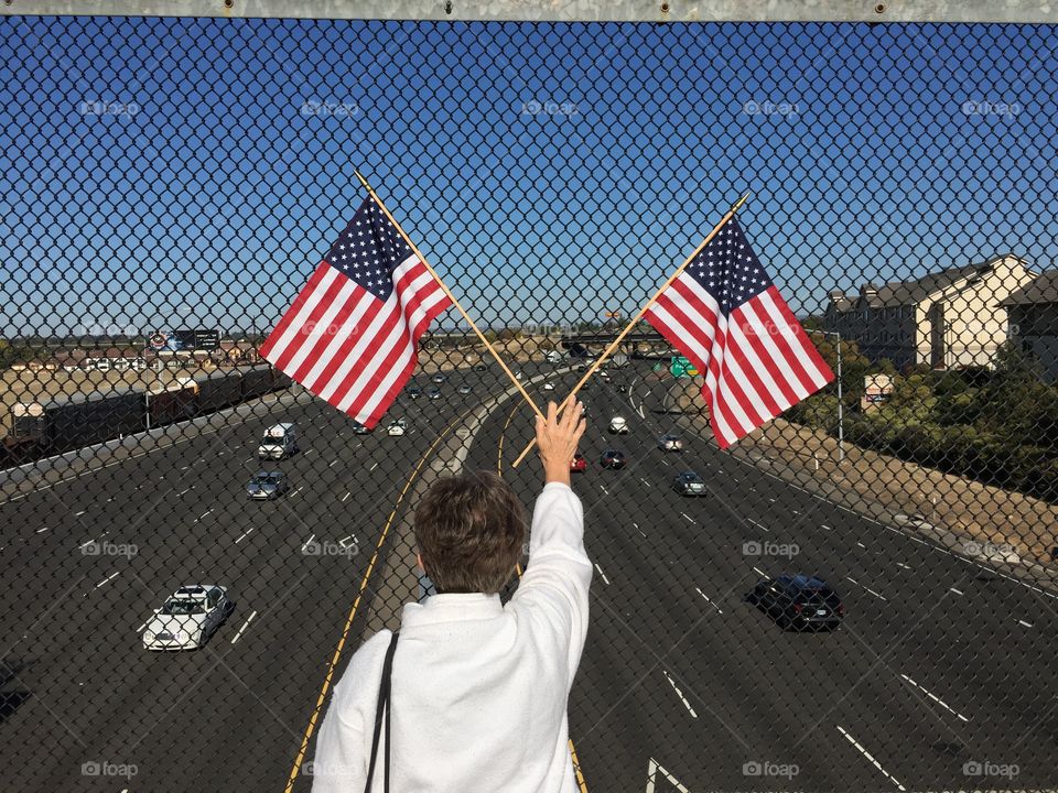 Woman holding two American flags on Memorial Day 