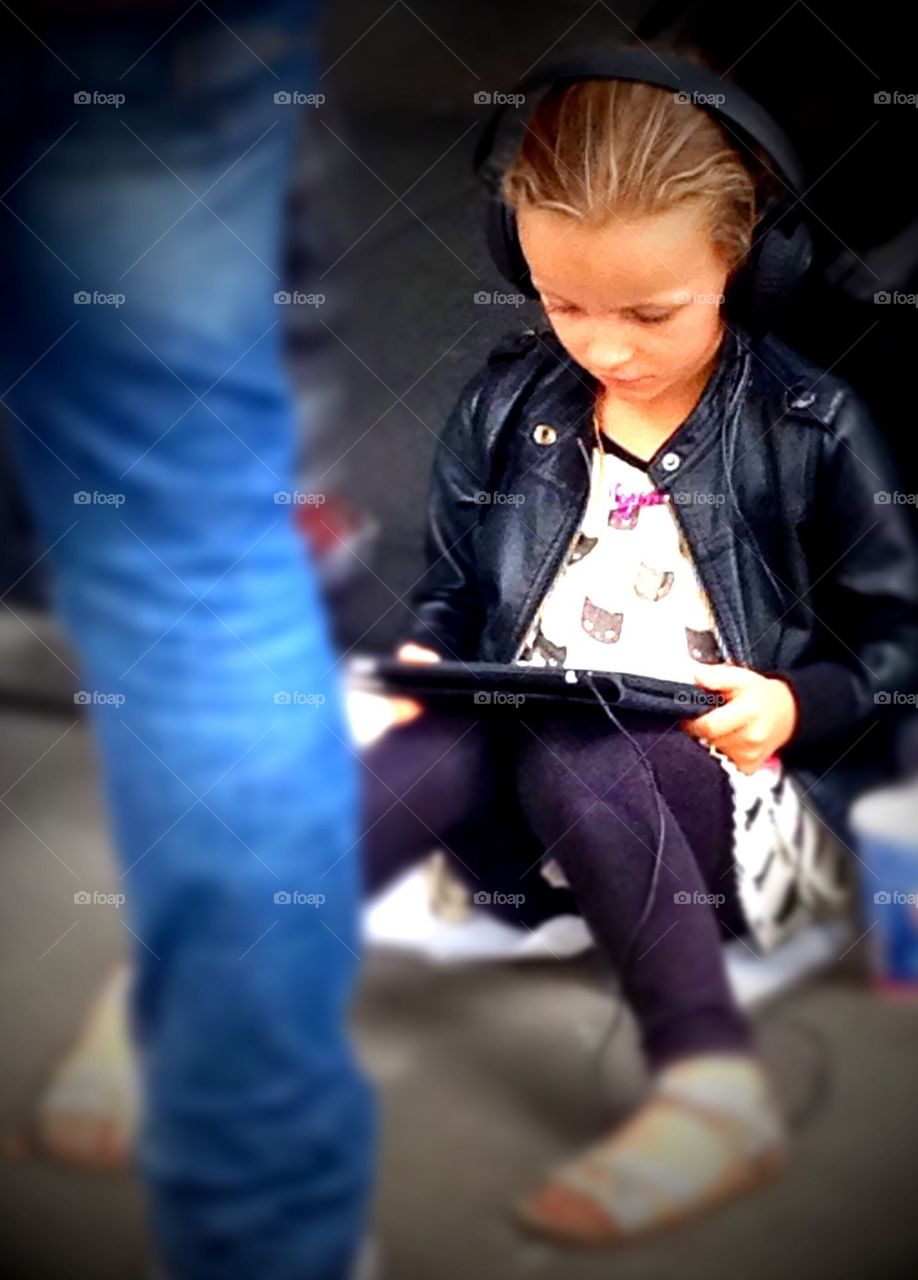 Connected young girl listening to music on iPad 