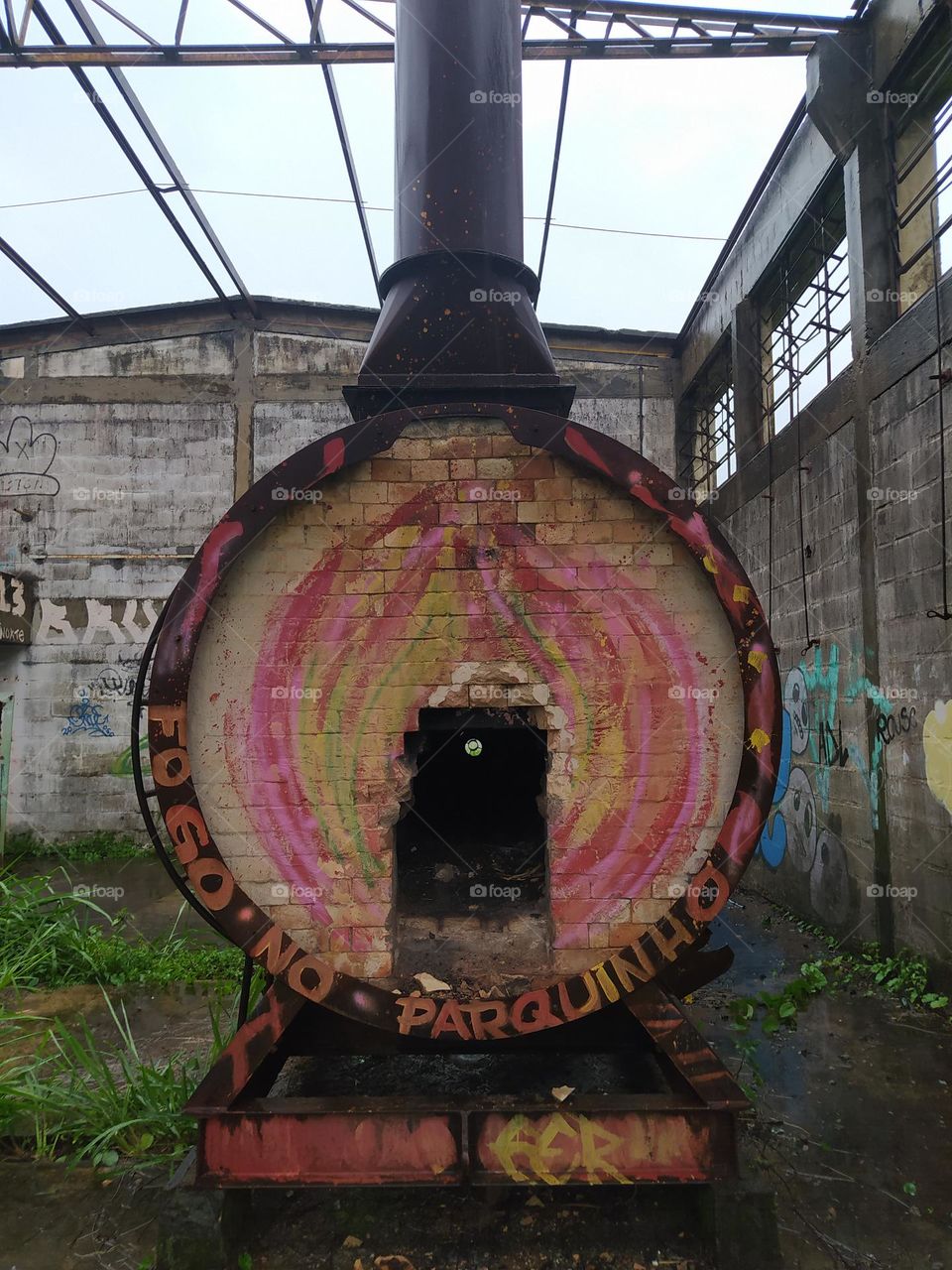 forno industrial abandonado em galpão.