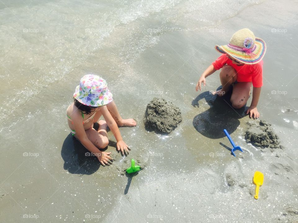 Two child playing on sandy beach