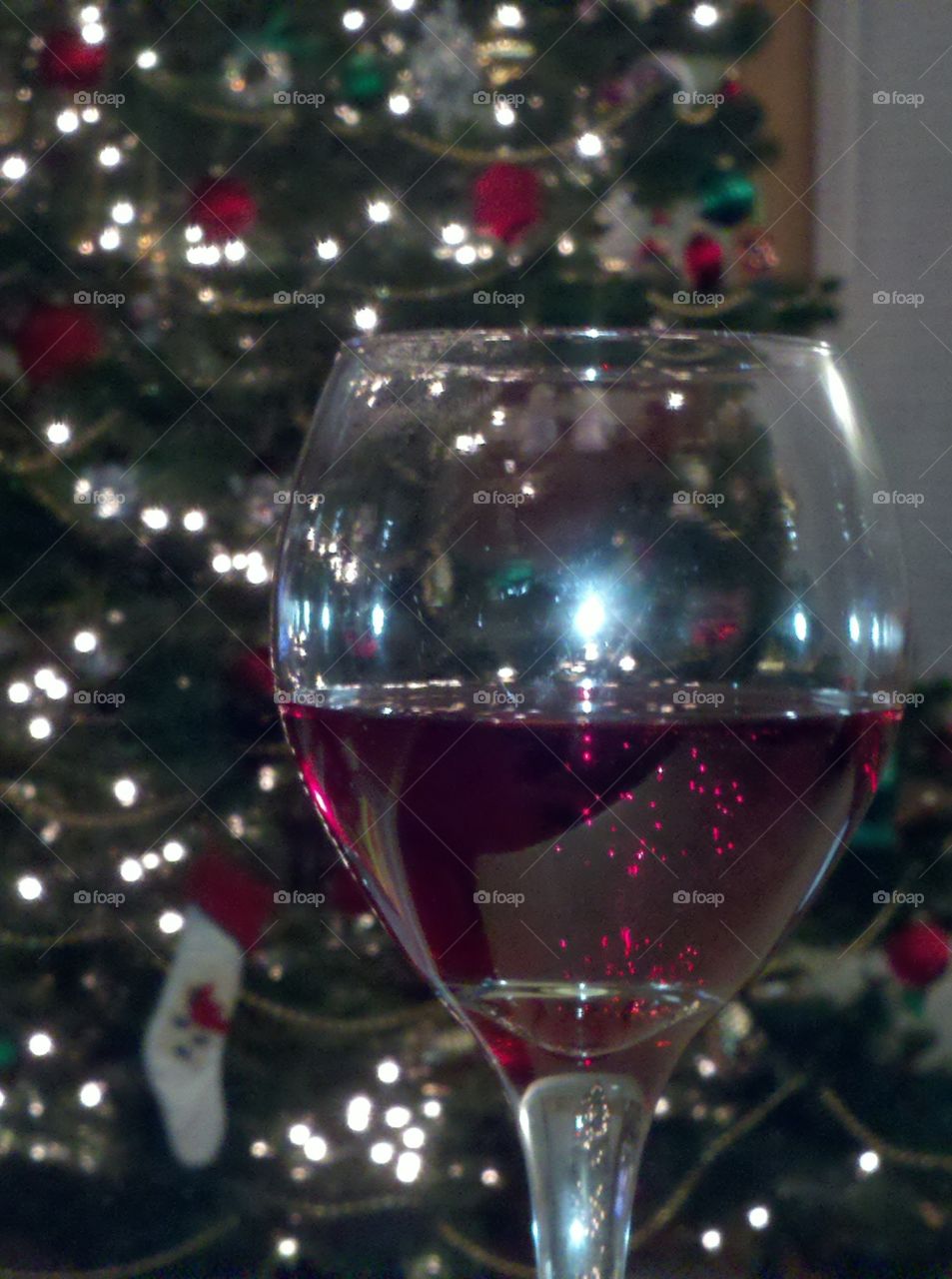 Glass of wine with Christmas Tree in background
