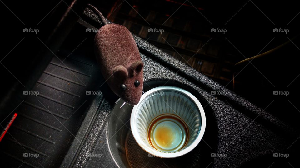 Um ratinho artificial próximo ao meu copinho descartavel de café.
