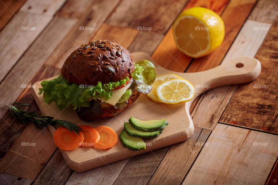 Dark burger with grain bread, cream cheese and avocado