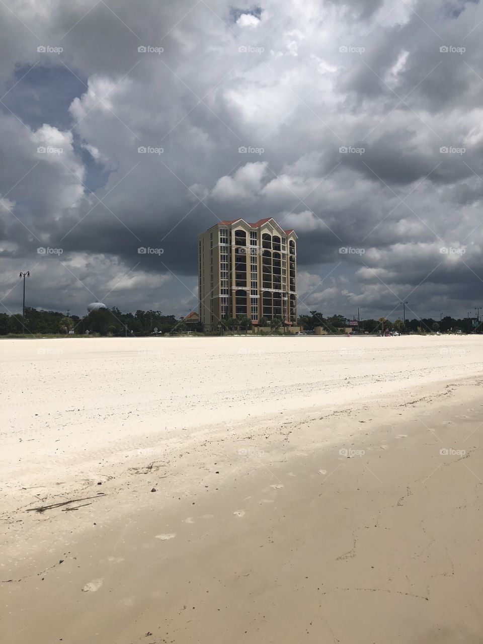 Beach , stormy sky and high rise building. 