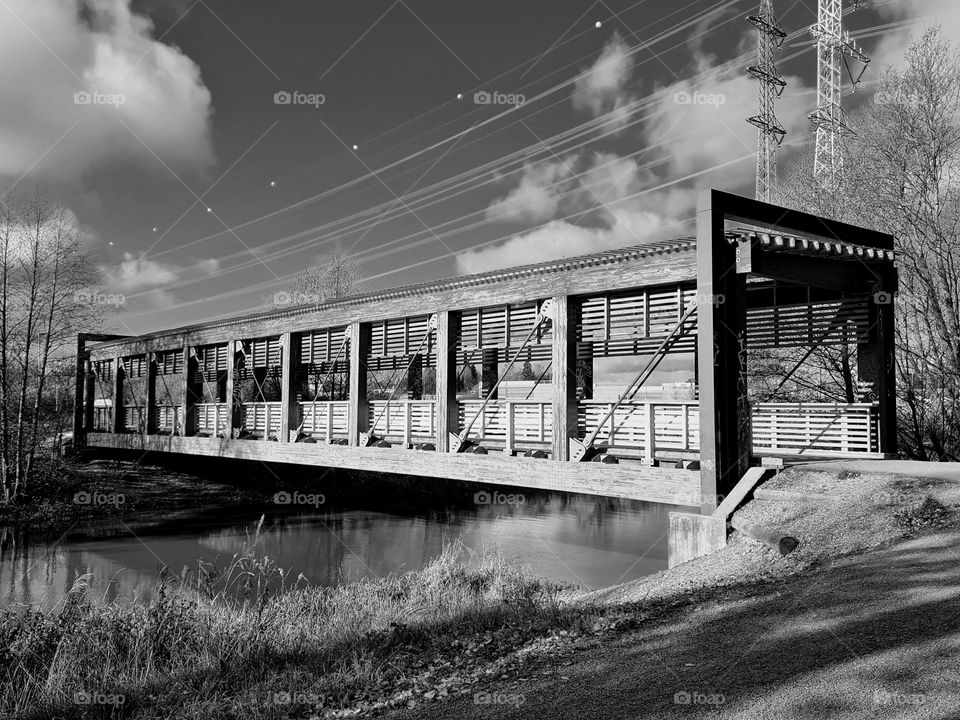 Black&white image of the side view of the old wooden rectangle shaped foot bridge