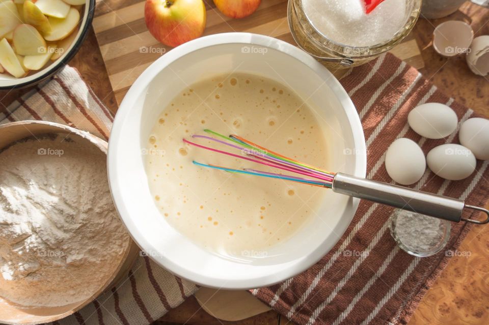 Making homemade puffed apple pie with eggs, sugar and flour.
