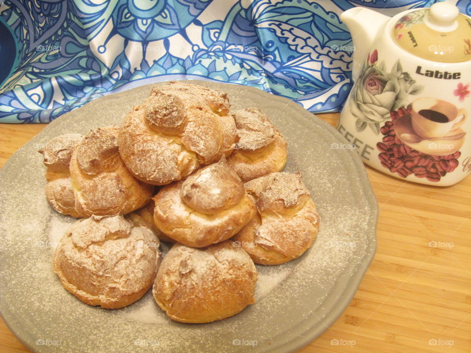 Profiteroles with white sweet cream with orange taste and a little bit of sugar in the top