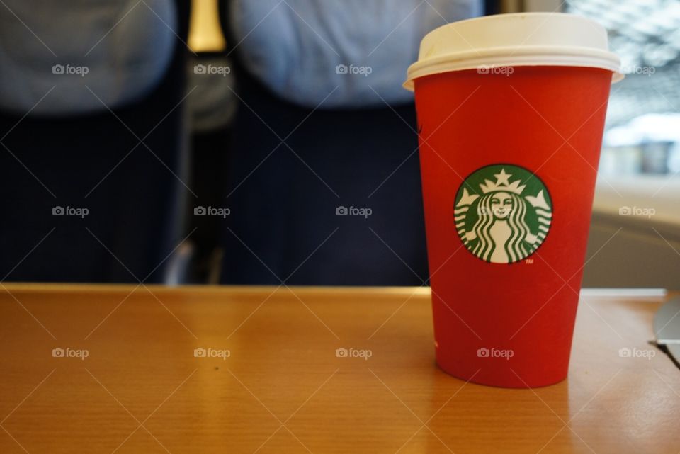 New red Starbucks coffee cup on a table in a train