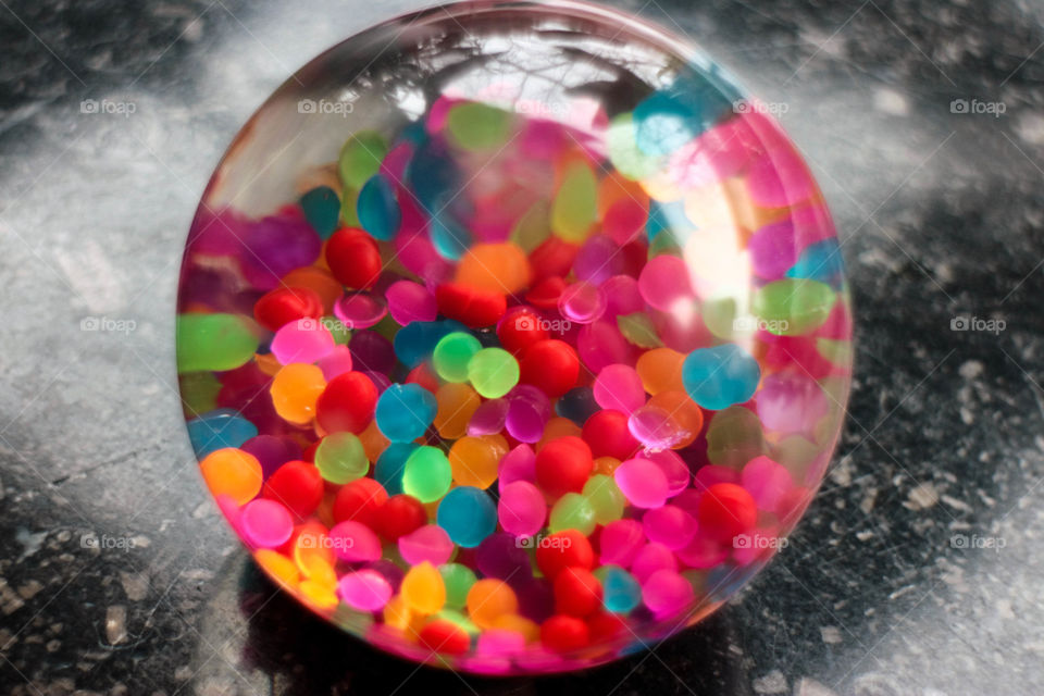 Super colorful little balls inside a transparent ball