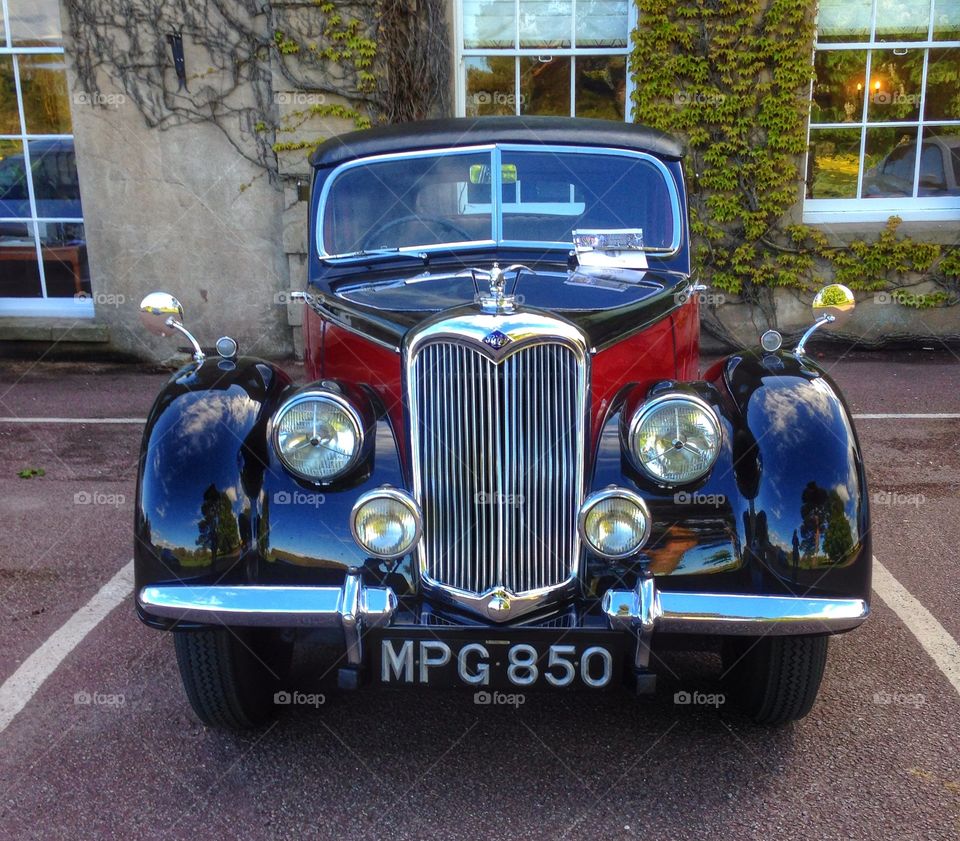 Riley motor car. Vintage car parked outside a stately home