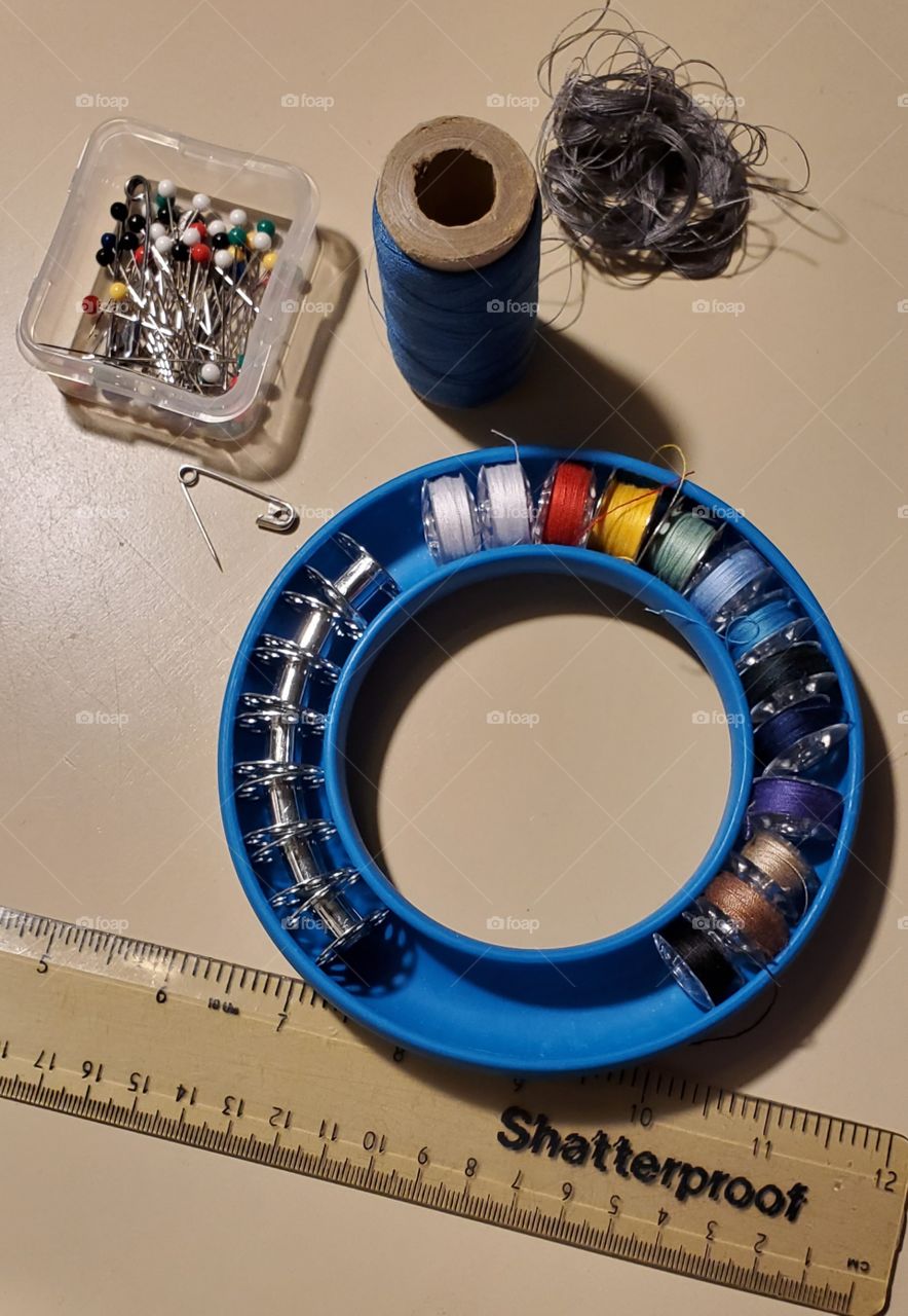 Sewing supplies laid out to easily reach while sewing. Variety of sewing threads ready to use.